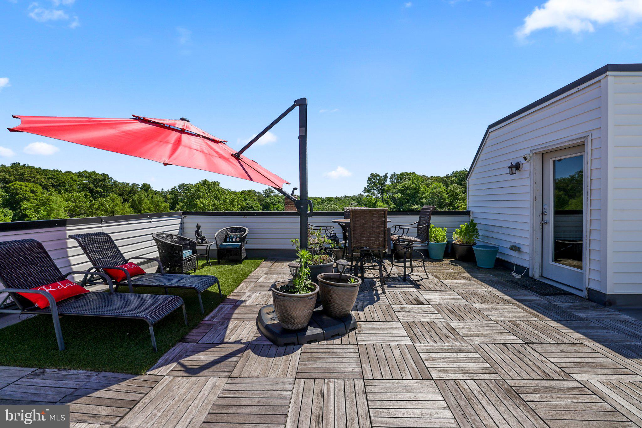 2221 M Street Northeast, Unit PH1 Washington, DC 20002 - Photo 1 of 38 a view of a patio with wooden chairs and a table