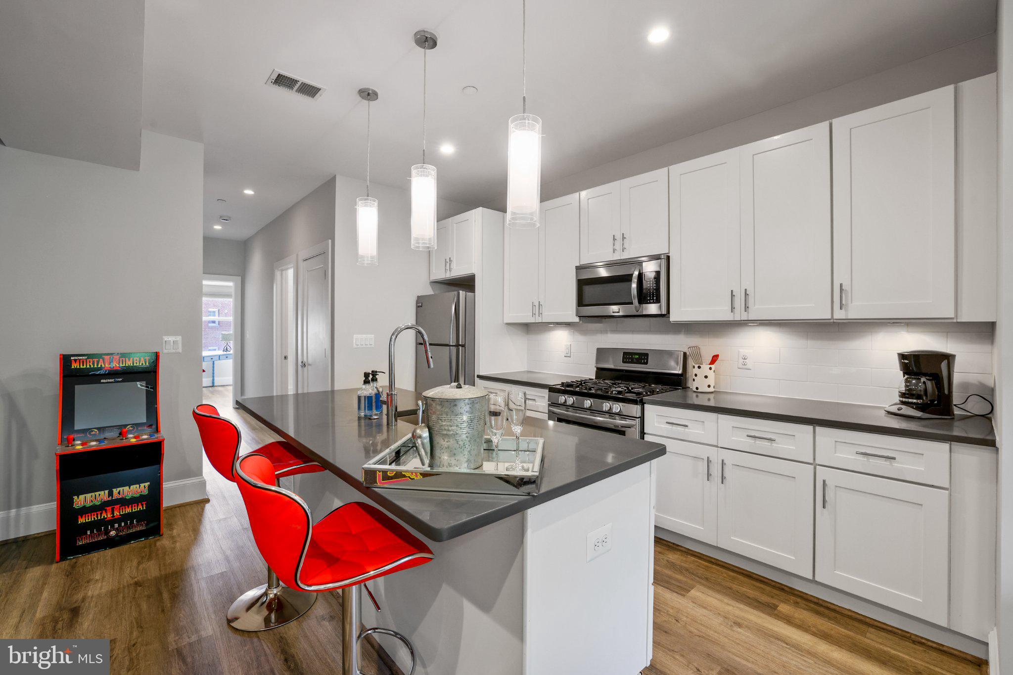 2221 M Street Northeast, Unit PH1 Washington, DC 20002 - Photo 2 of 38 a kitchen with stainless steel appliances granite countertop a stove top oven a sink a counter space and cabinets