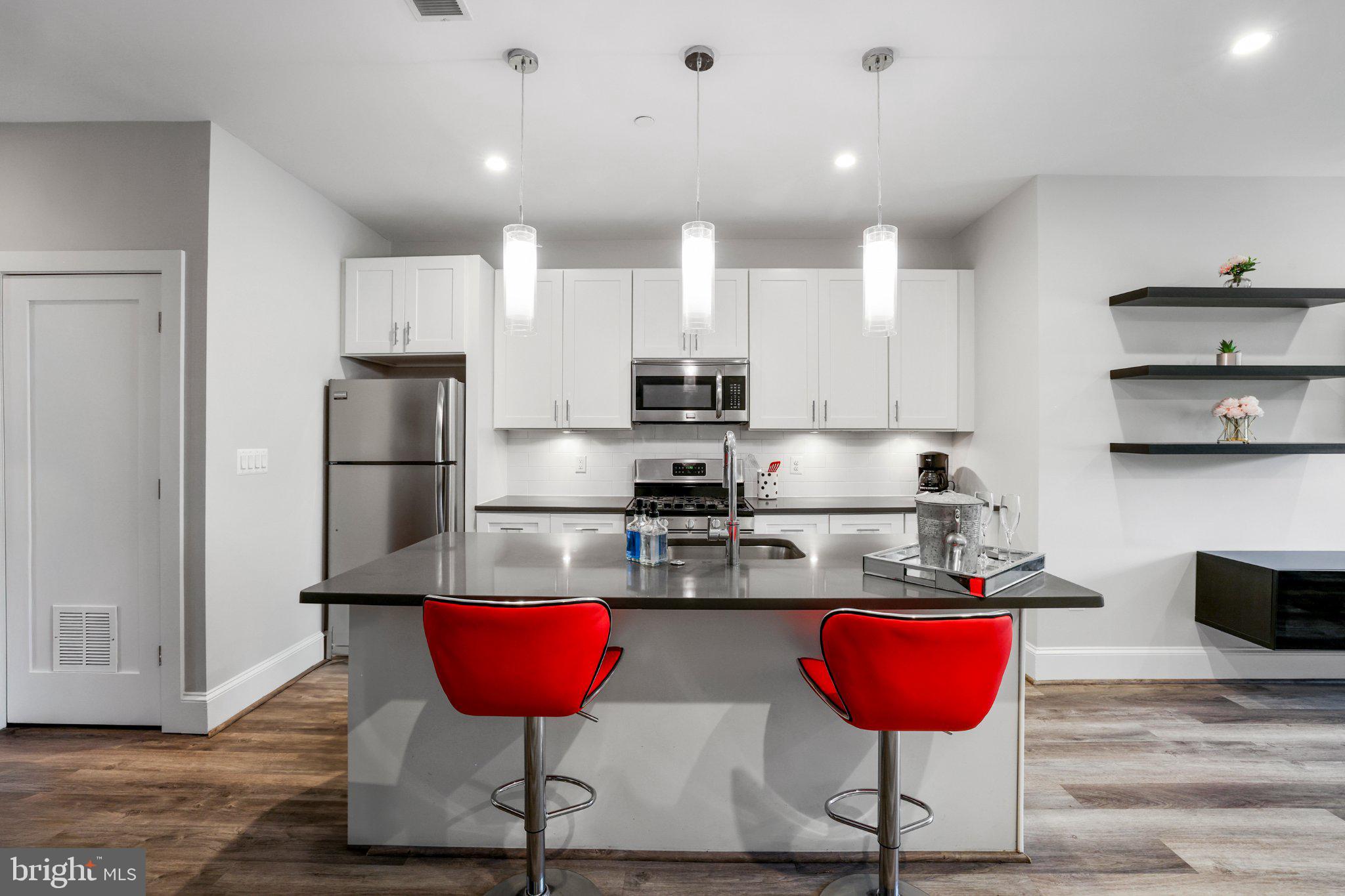 2221 M Street Northeast, Unit PH1 Washington, DC 20002 - Photo 3 of 38 a kitchen with stainless steel appliances granite countertop a refrigerator and a stove top oven