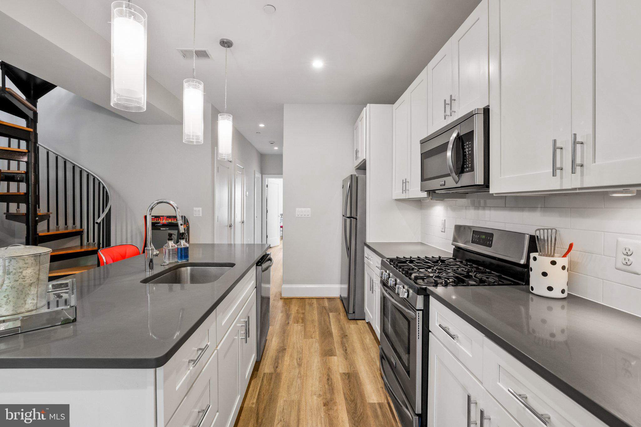 2221 M Street Northeast, Unit PH1 Washington, DC 20002 - Photo 4 of 38 a kitchen with stainless steel appliances granite countertop a sink stove and refrigerator