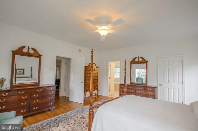 a bedroom with a bed and a large mirror on the dresser