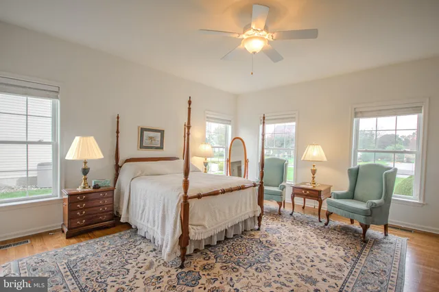 a bedroom with a bed a chair and a chandelier