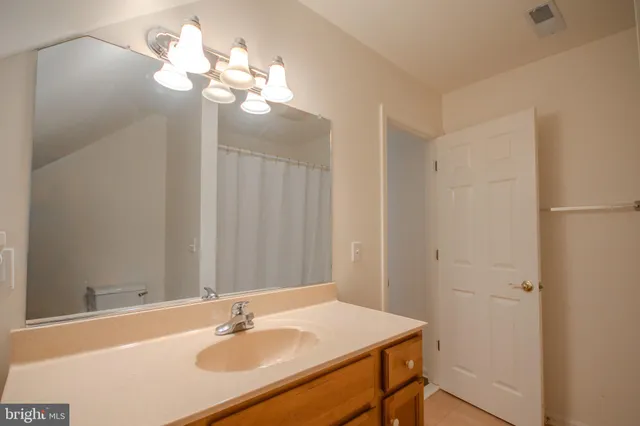 a bathroom with a sink a light fixture and a mirror