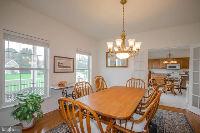 a dining room with furniture a chandelier and wooden floor