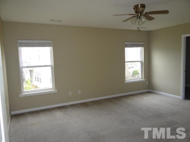4027 Flat Sedge Lane Raleigh, NC 27604 - Photo 7 of 11 an empty room with windows and fan
