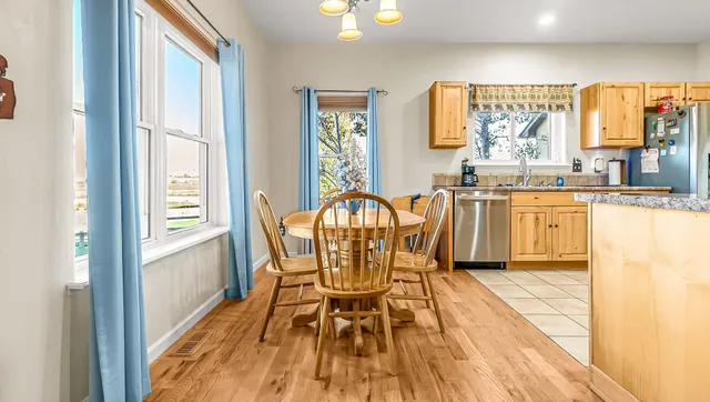 a view of a kitchen with kitchen island granite countertop wooden floor and a dining table