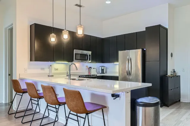 a kitchen with stainless steel appliances a microwave a sink and a refrigerator