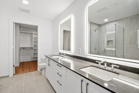 a spacious bathroom with a double vanity sink and mirror