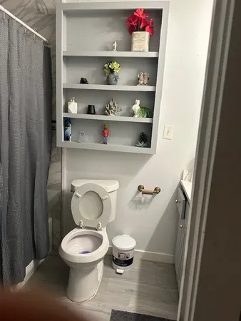 a white toilet sitting next to a bathroom sink and a mirror
