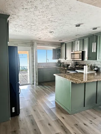 a kitchen with stainless steel appliances granite countertop a stove a sink and a refrigerator