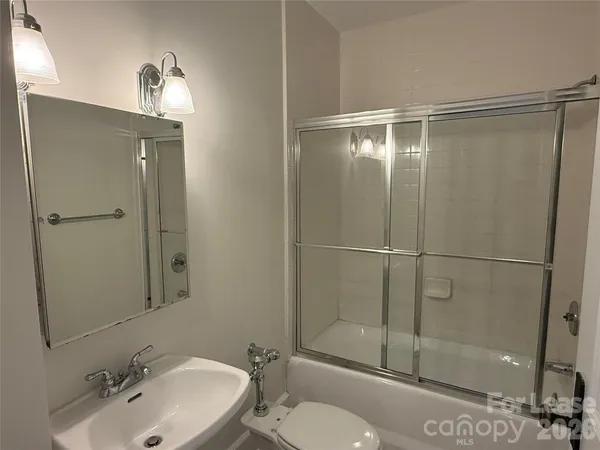 a bathroom with a shower a sink and toilet