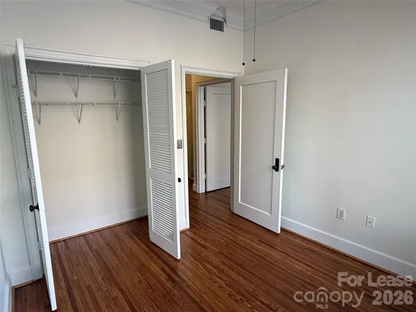 an empty room with wooden floor and closet
