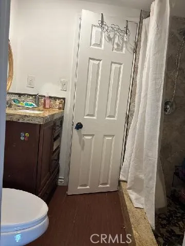 a bathroom with a sink a toilet a mirror and shower