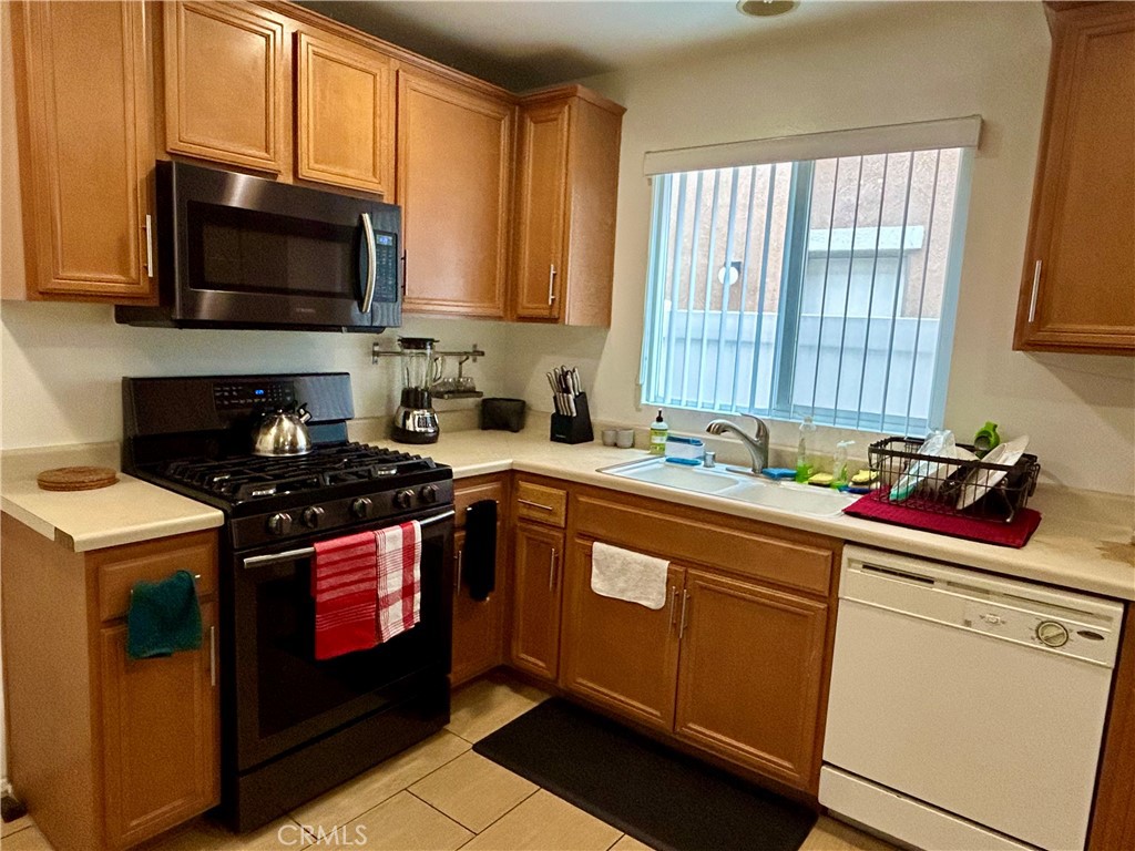567 Botan Street Perris, CA 92571 - Photo 14 of 38 a kitchen with stainless steel appliances a stove microwave and sink