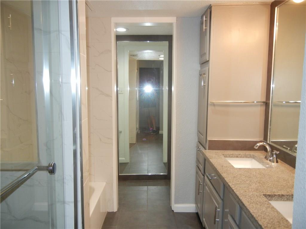18240 Midway Road, Unit 105 Dallas, TX 75287 - Photo 14 of 37 a en suite bathroom with a granite countertop sink and a mirror
