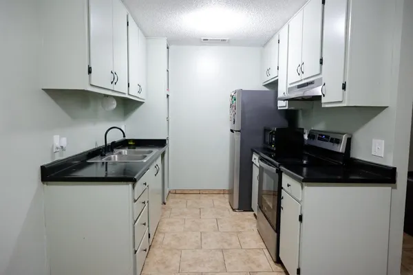 a kitchen with granite countertop a sink and a stove