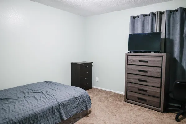 a bedroom with a bed and a flat screen tv