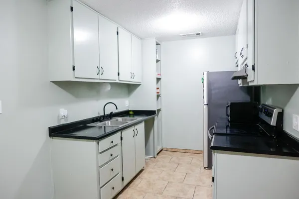 a kitchen with granite countertop a stove and a refrigerator
