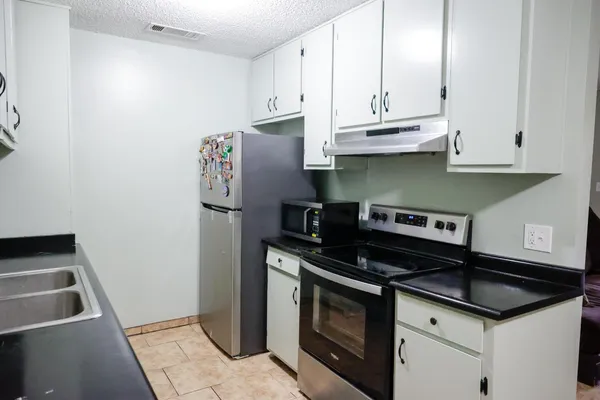 a kitchen with granite countertop a sink and a stove