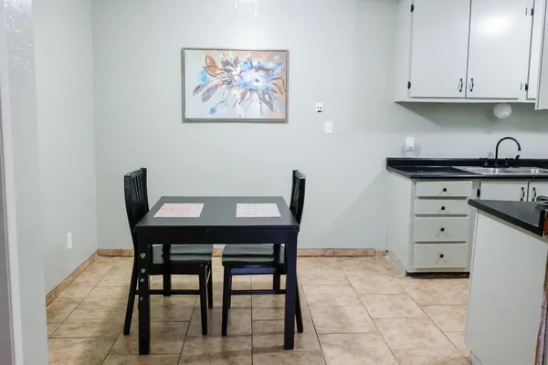 a kitchen with stainless steel appliances kitchen island granite countertop a table chairs and a refrigerator