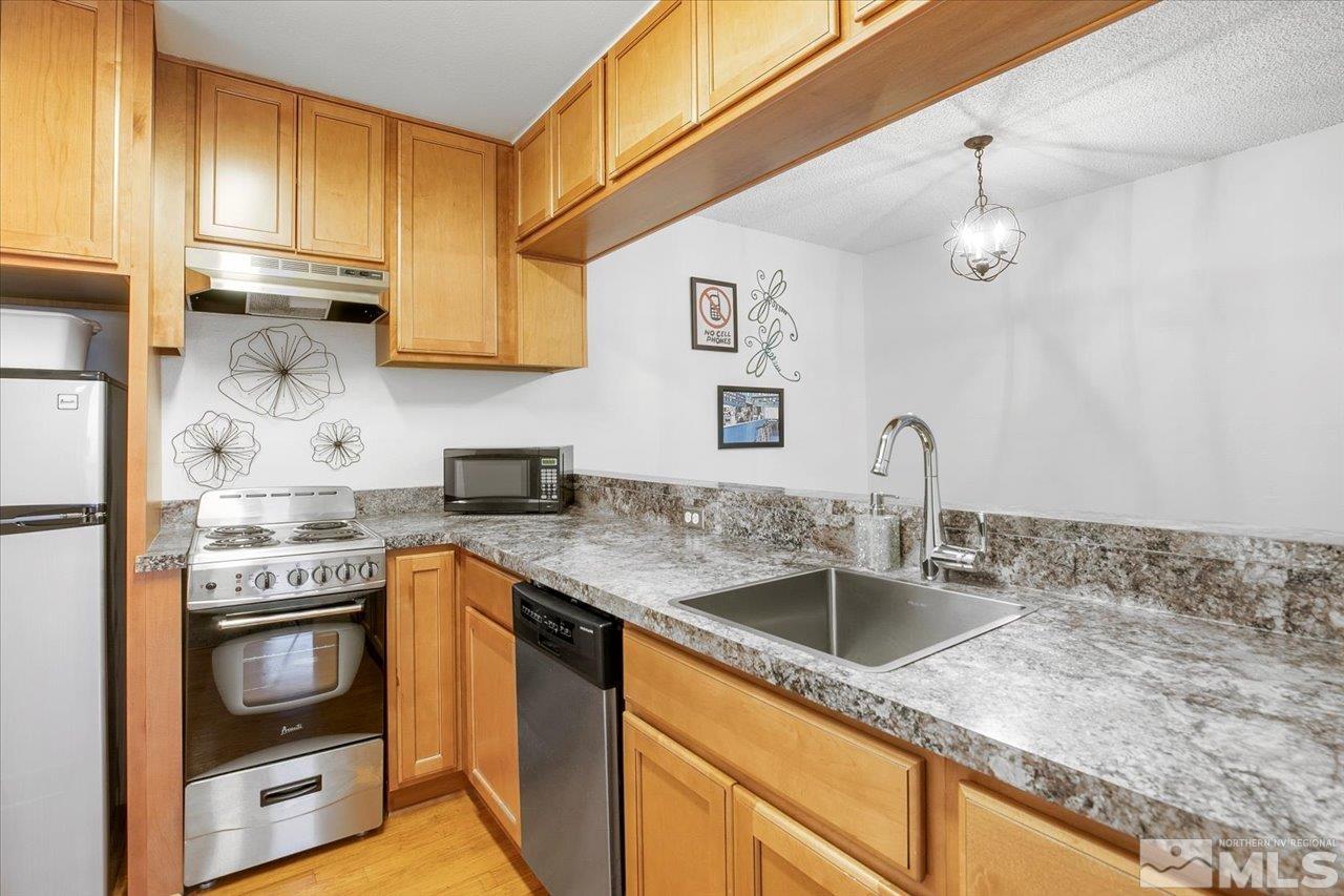 a kitchen with stainless steel appliances granite countertop a sink stove and refrigerator