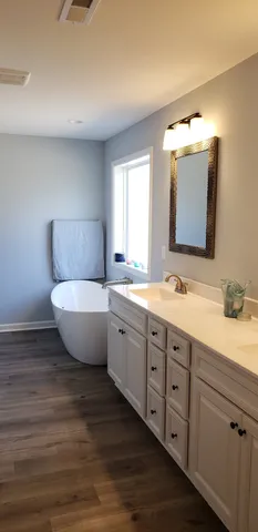 a bathroom with a granite countertop sink mirror and bathtub