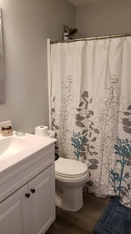 a bathroom with a granite countertop sink and a toilet