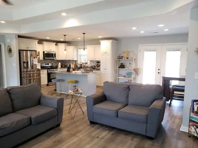 a living room with furniture and kitchen view