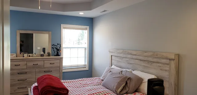 a bedroom with a bed and a mirror