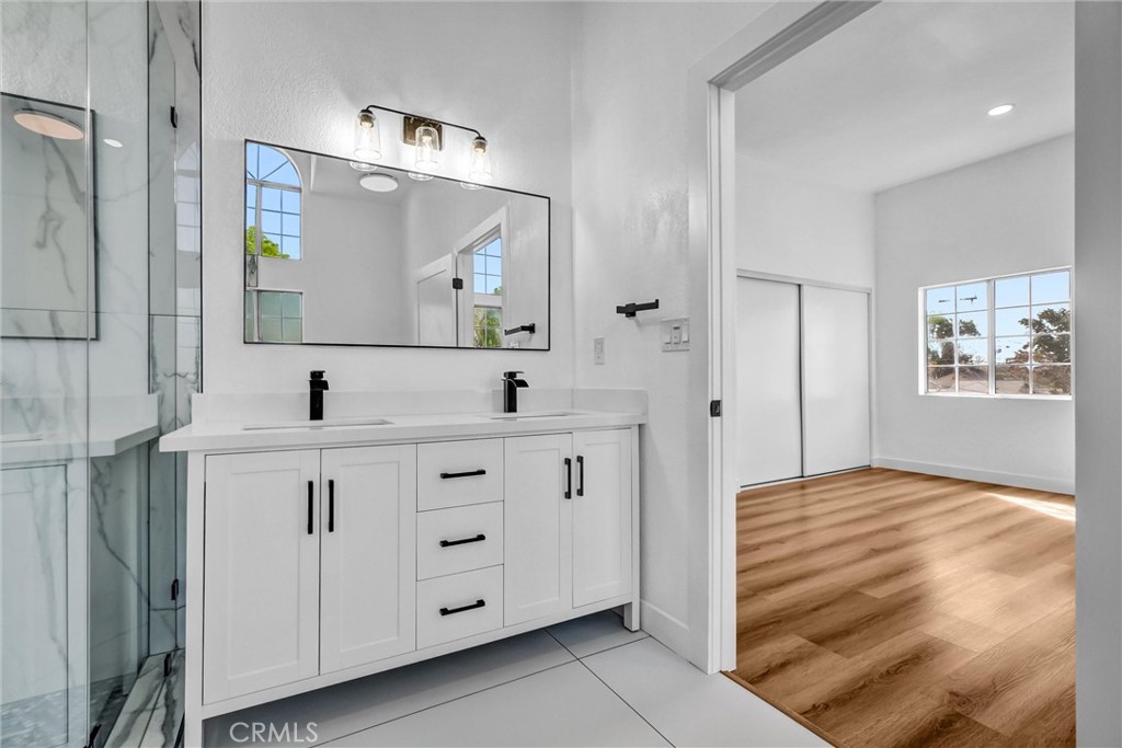 1200 South Castlegate Avenue Compton, CA 90221 - Photo 33 of 39 a bathroom with a double vanity sink and mirror