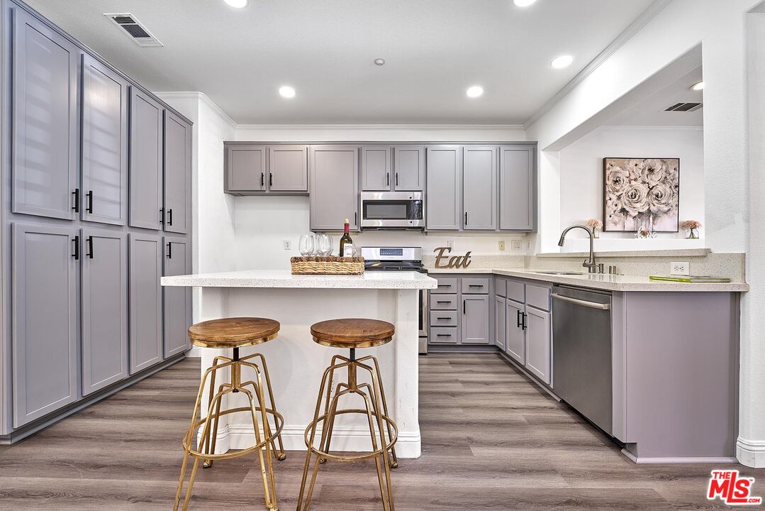 38 Windward Way Buena Park, CA 90621 - Photo 13 of 71 a kitchen with stainless steel appliances granite countertop a table chairs sink refrigerator and cabinets
