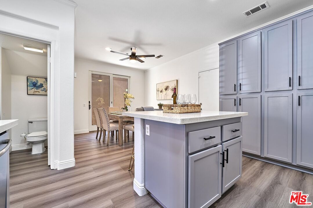 38 Windward Way Buena Park, CA 90621 - Photo 16 of 71 a kitchen with kitchen island white cabinets and stainless steel appliances