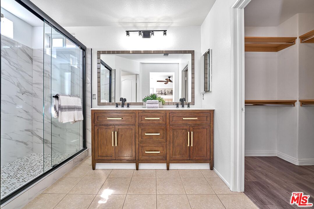 38 Windward Way Buena Park, CA 90621 - Photo 43 of 71 a bathroom with a granite countertop sink a mirror and a shower
