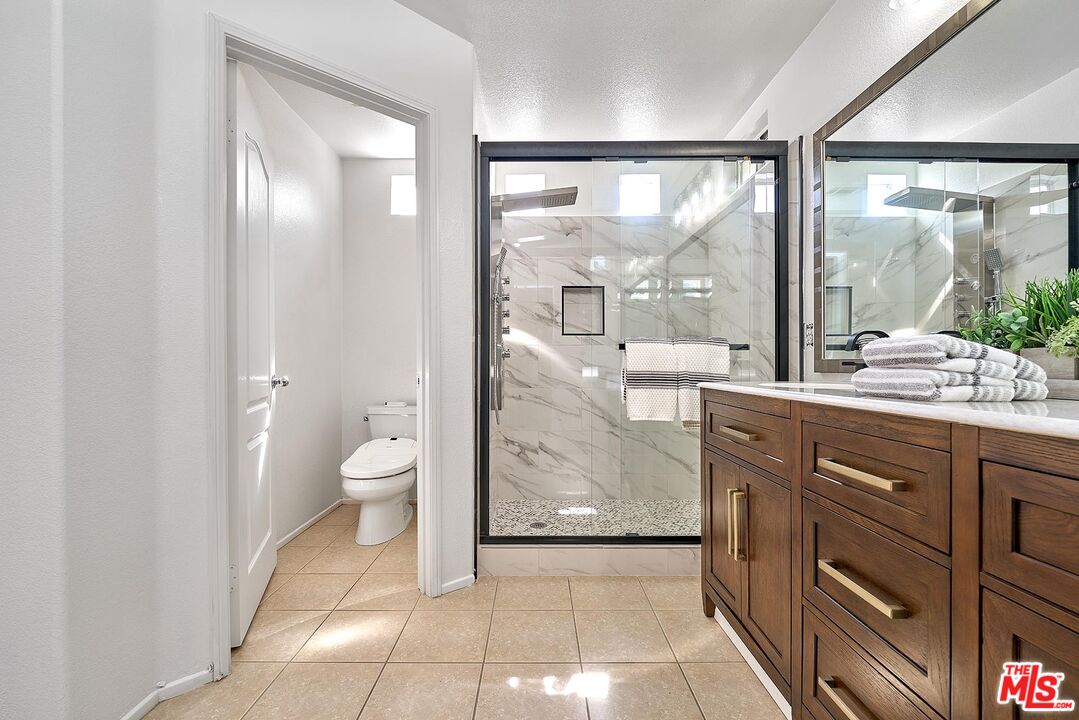 38 Windward Way Buena Park, CA 90621 - Photo 45 of 71 a bathroom with a granite countertop sink toilet a large mirror next to a window