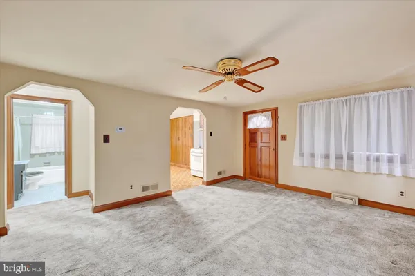 an empty room with fan and windows