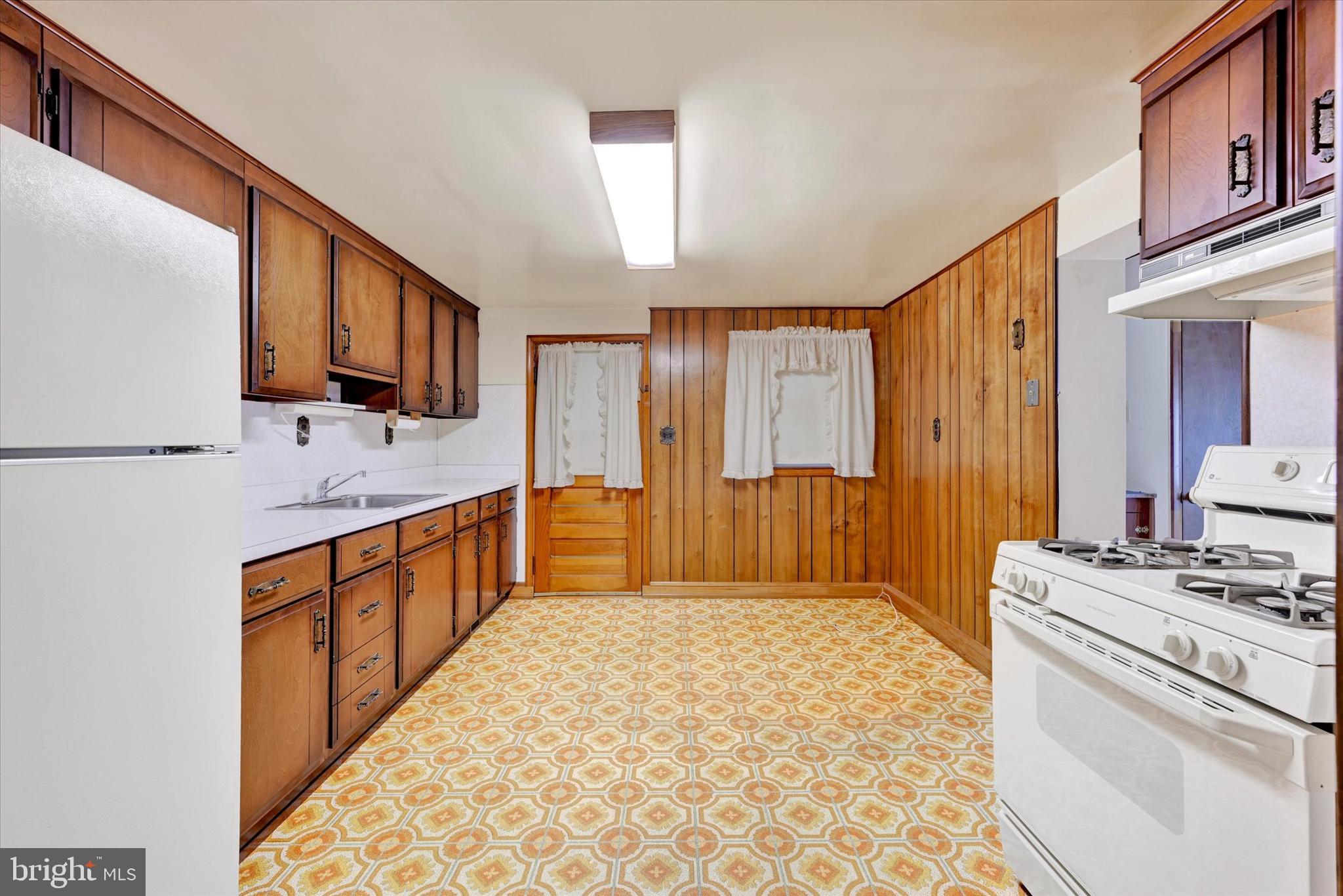 7437 New Cut Road Kingsville, MD 21087 - Photo 10 of 56 a large white kitchen with stainless steel appliances a stove a sink and a refrigerator