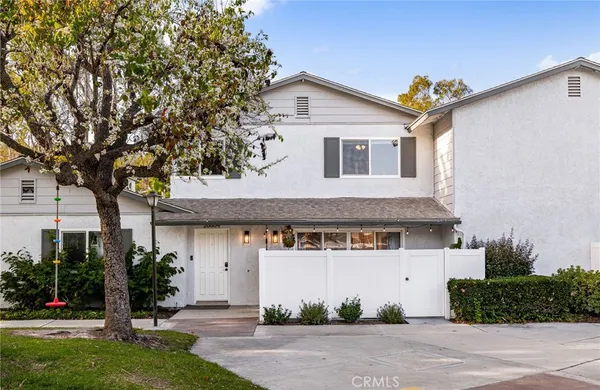 a front view of a house with a tree and plants