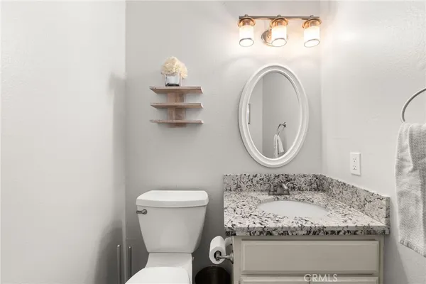 a bathroom with a toilet mirror and vanity