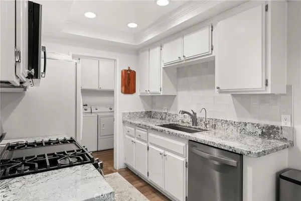 a kitchen with stainless steel appliances granite countertop a sink stove and cabinets