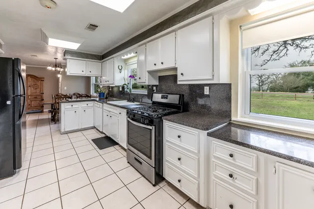 a kitchen with granite countertop white cabinets and appliances