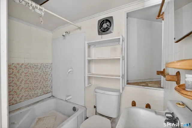 a bathroom with a toilet sink and shower