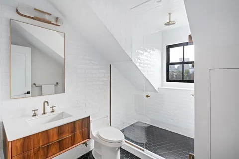 a bathroom with a granite countertop sink toilet a mirror and shower