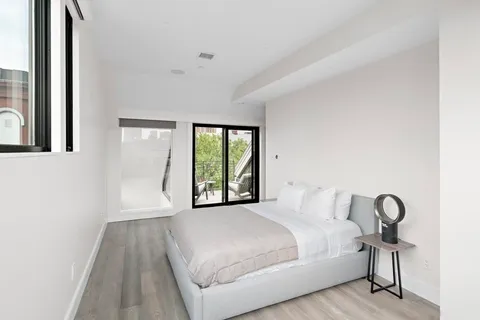 a bedroom with a bed and a large window