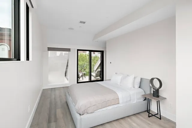 a bedroom with a bed and a large window