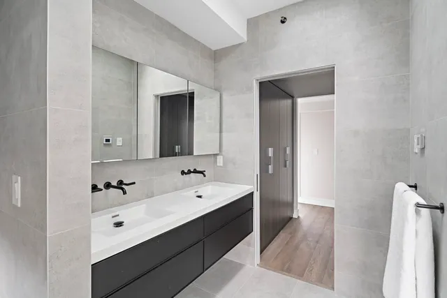 a en suite bathroom with a double vanity sink a mirror and a bathtub