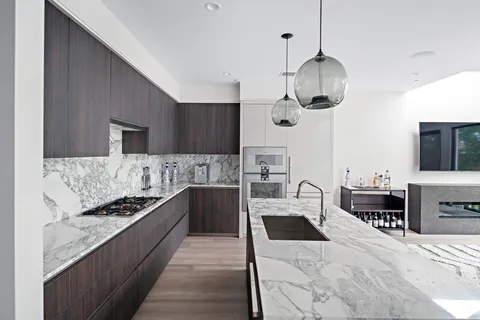 a kitchen with stainless steel appliances kitchen island granite countertop a stove and a sink