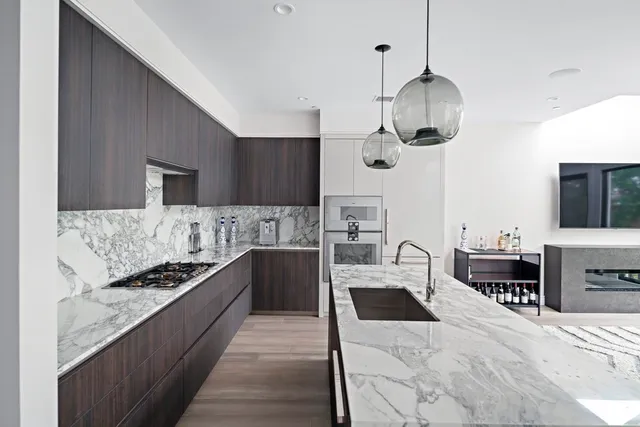 a kitchen with stainless steel appliances kitchen island granite countertop a stove and a sink