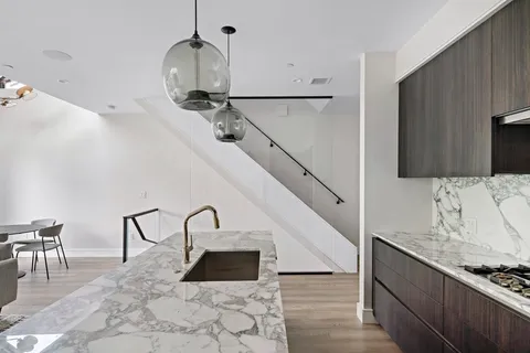 a kitchen with sink a stove and chairs
