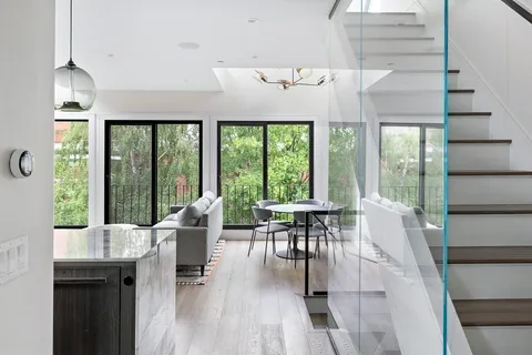 a dining room with wooden floor furniture and a floor to ceiling window