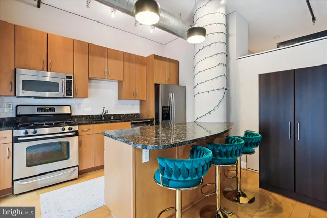 a kitchen with stainless steel appliances granite countertop a stove a sink and a microwave